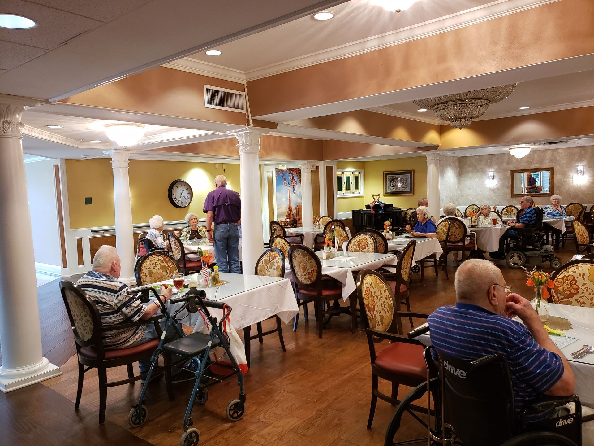 A group of people are sitting at tables in a large dining room.