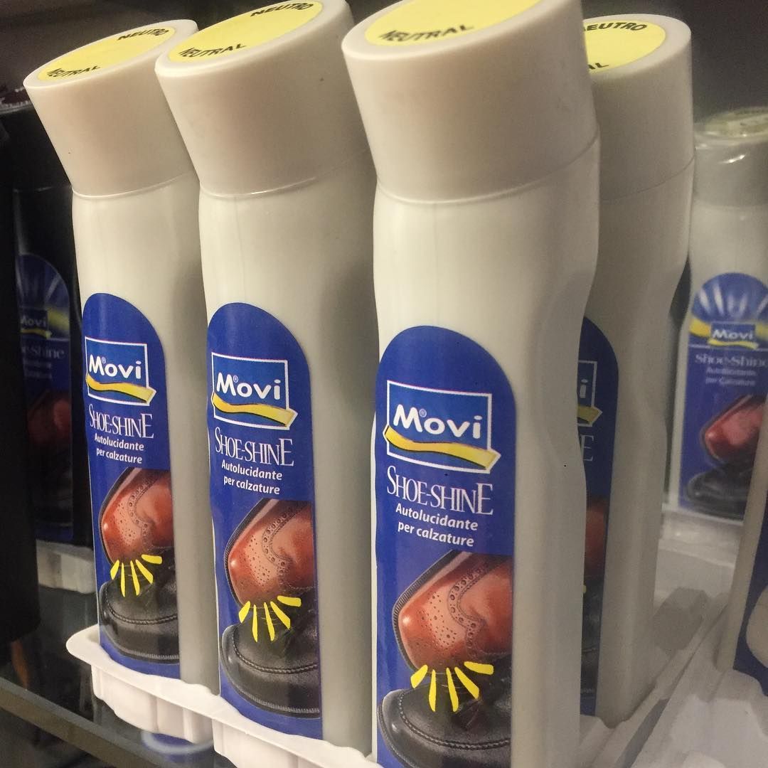 Una fila di flaconi bianchi di Movi Shine su uno scaffale di un negozio, con etichette blu e tappi gialli.