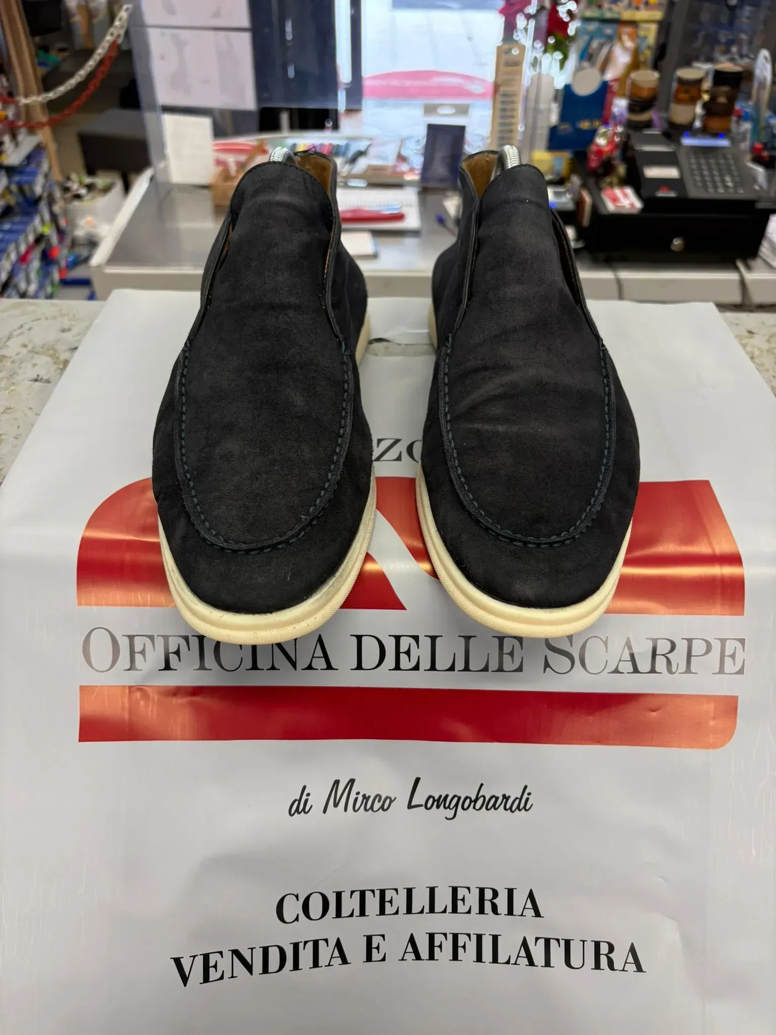 Scarpe nere senza lacci su una scatola in un espositore di un negozio.