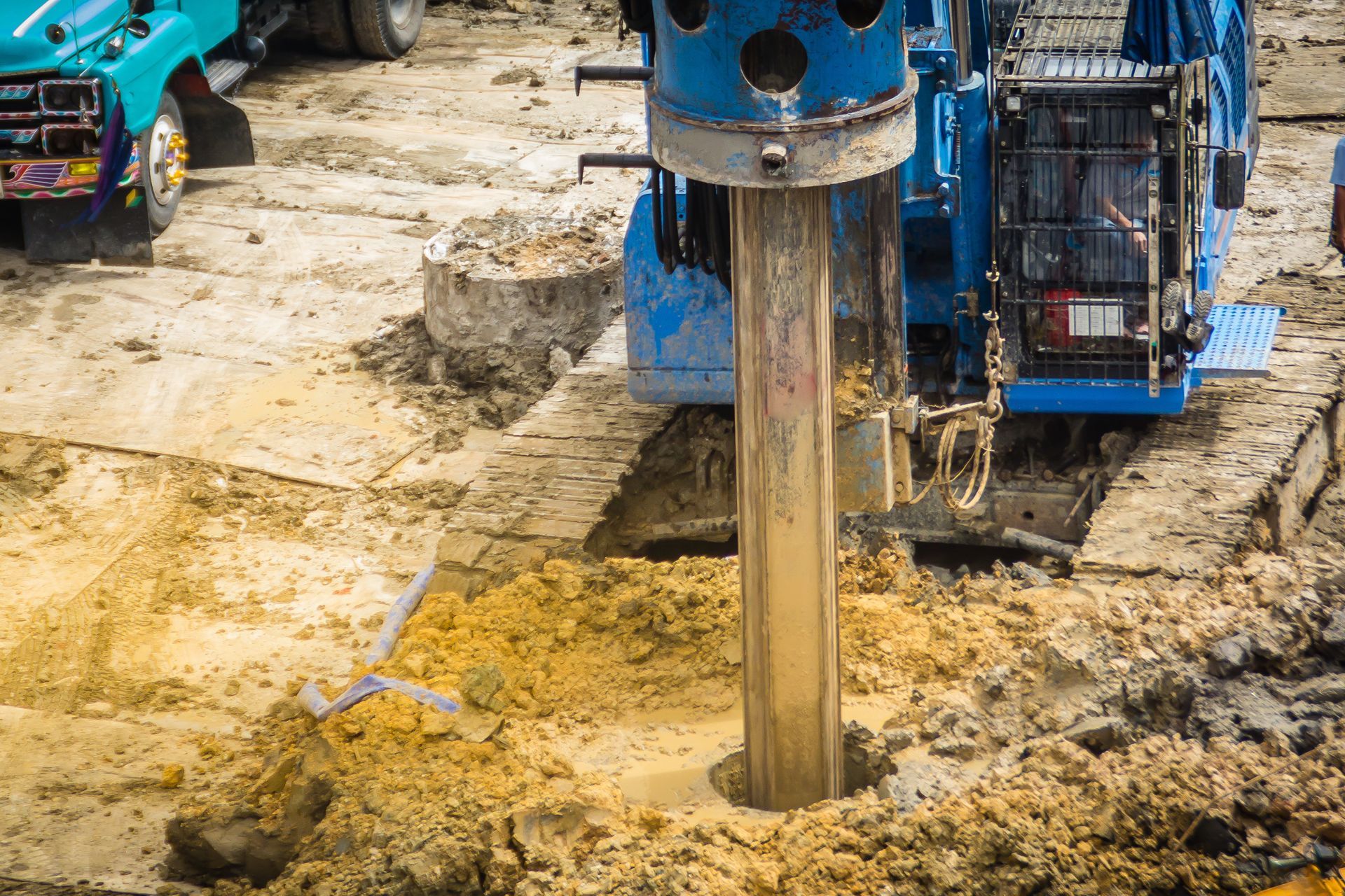 Blue rotary drilling rig bores deep into wet, sandy soil at an active water well replacement site. Blue rotary drilling rig bores deep into wet, sandy soil at an active water well replacement site.