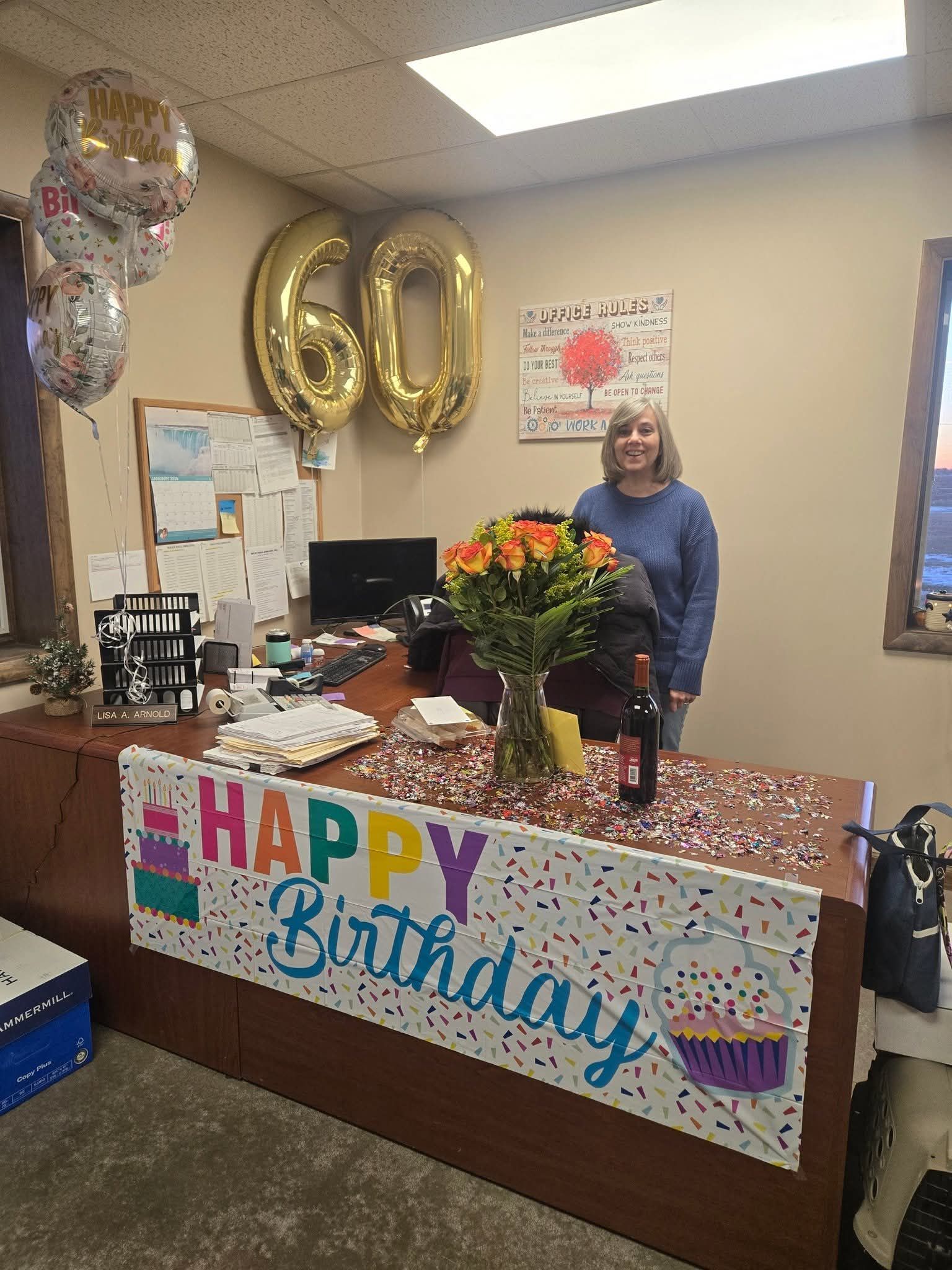 A person stands behind a desk decorated with a