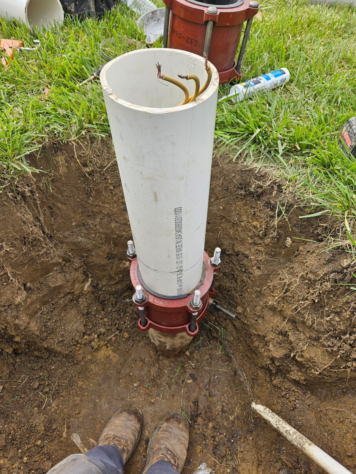 A Person Is fixing A Pipe In The Dirt - Union City, IN - Wiley Well Drilling