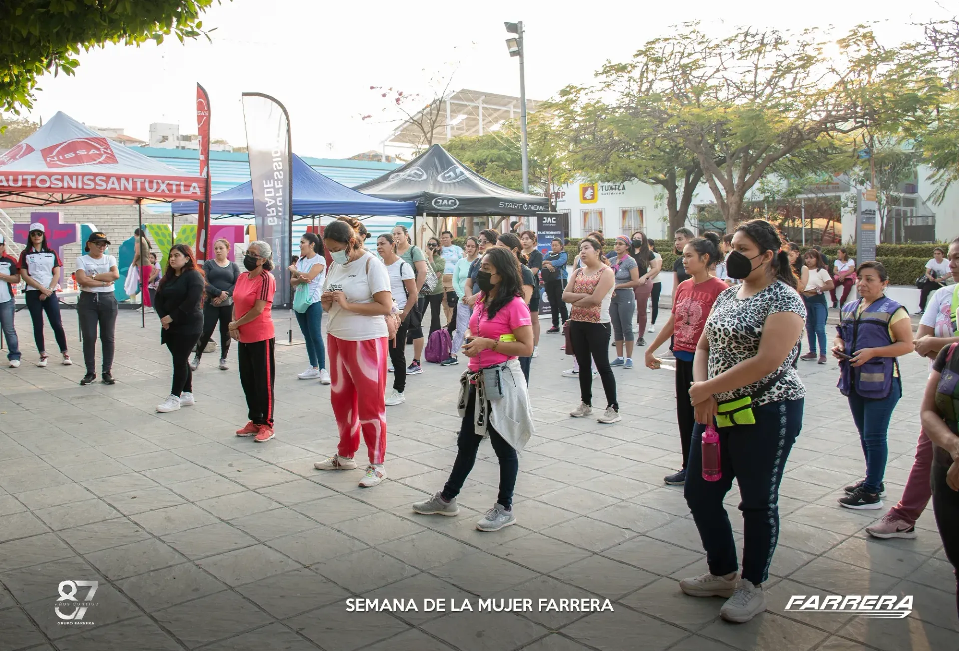 Un grupo de personas realiza ejercicio al aire libre en una plaza