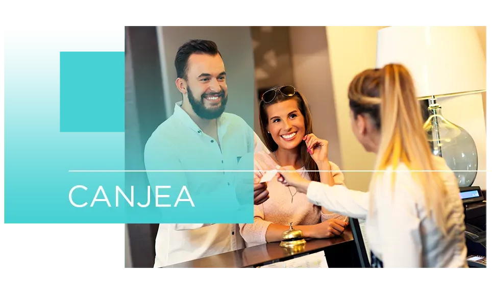 Dos personas intercambiando una tarjeta en un mostrador de recepción con un panel turquesa con la etiqueta “CANJEA”.