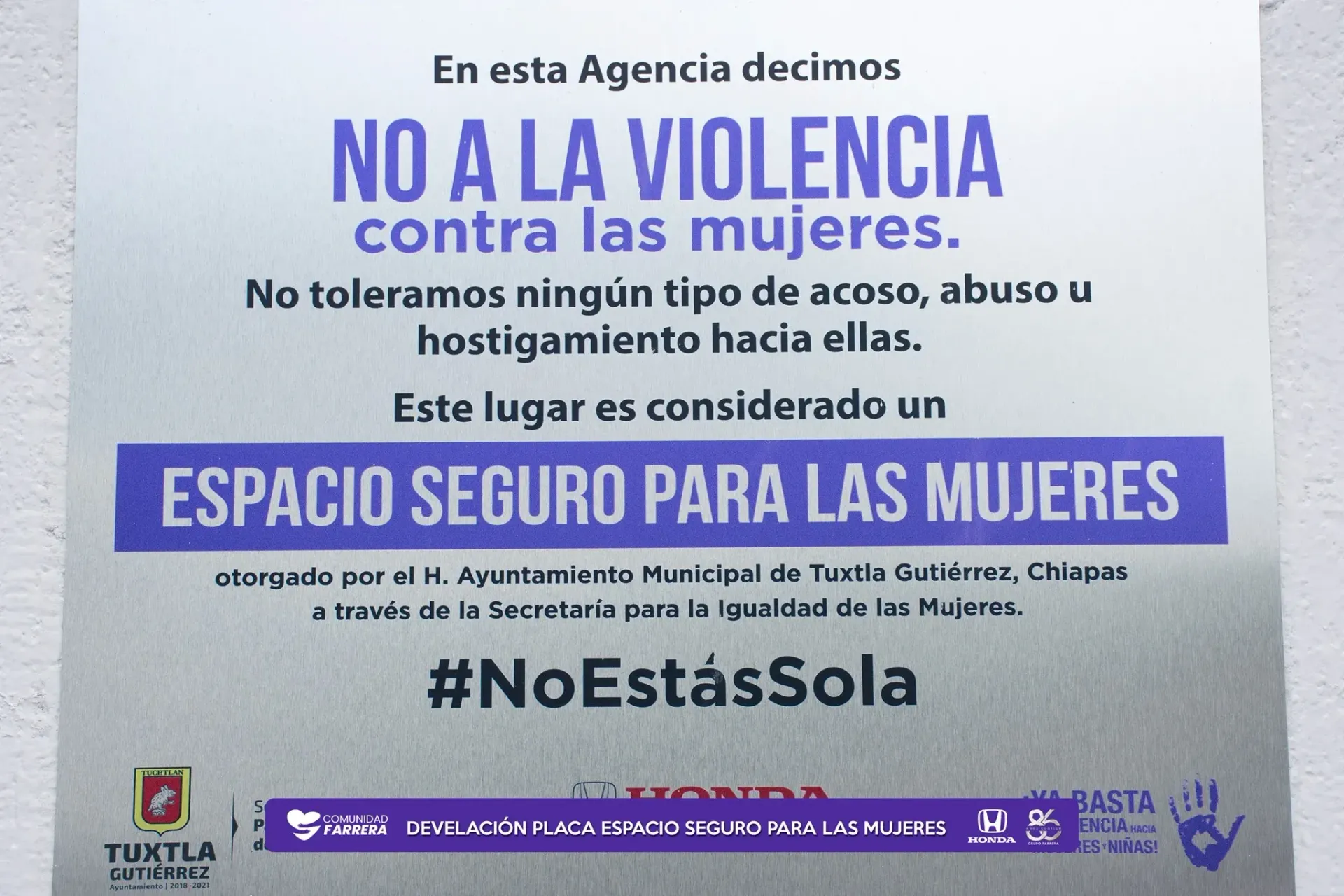 Cartel morado y blanco que declara “No a la violencia contra las mujeres” y “Espacio seguro para las mujeres”