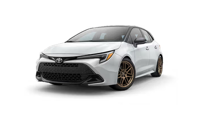 Coche Toyota hatchback blanco en estudio, mostrado desde el ángulo frontal izquierdo.