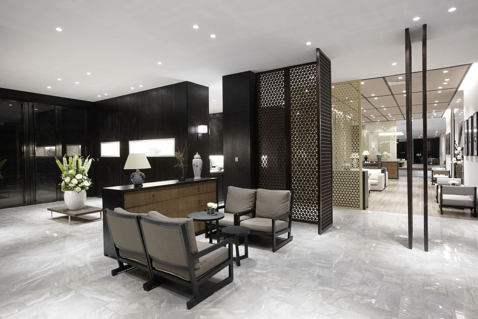 Elegant jewelry store interior with seating area and decorative screens, gray marble floor.