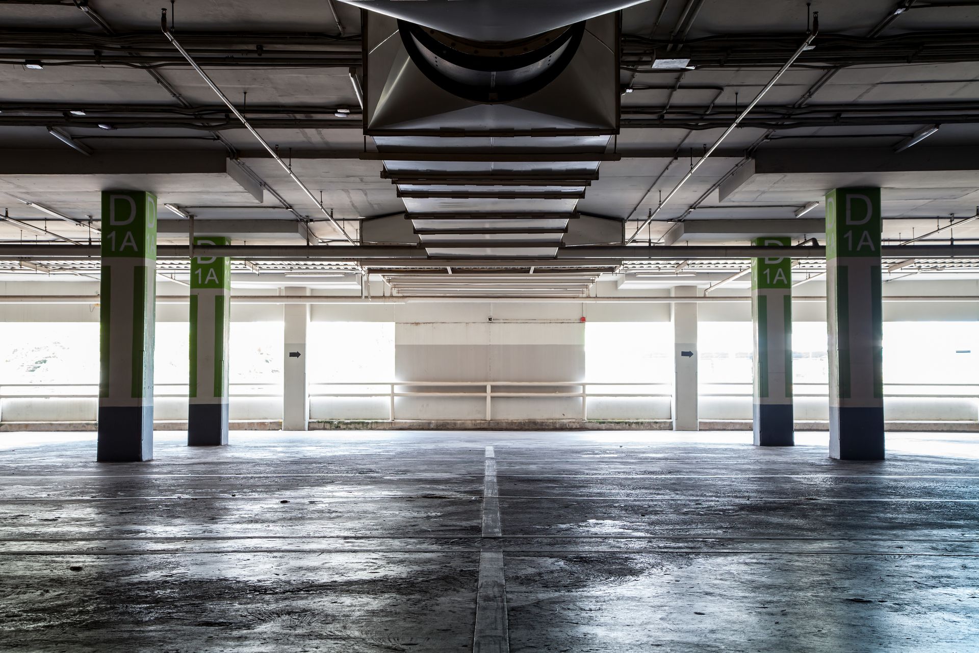 Empty, indoor parking garage with concrete floors, pillars marked 