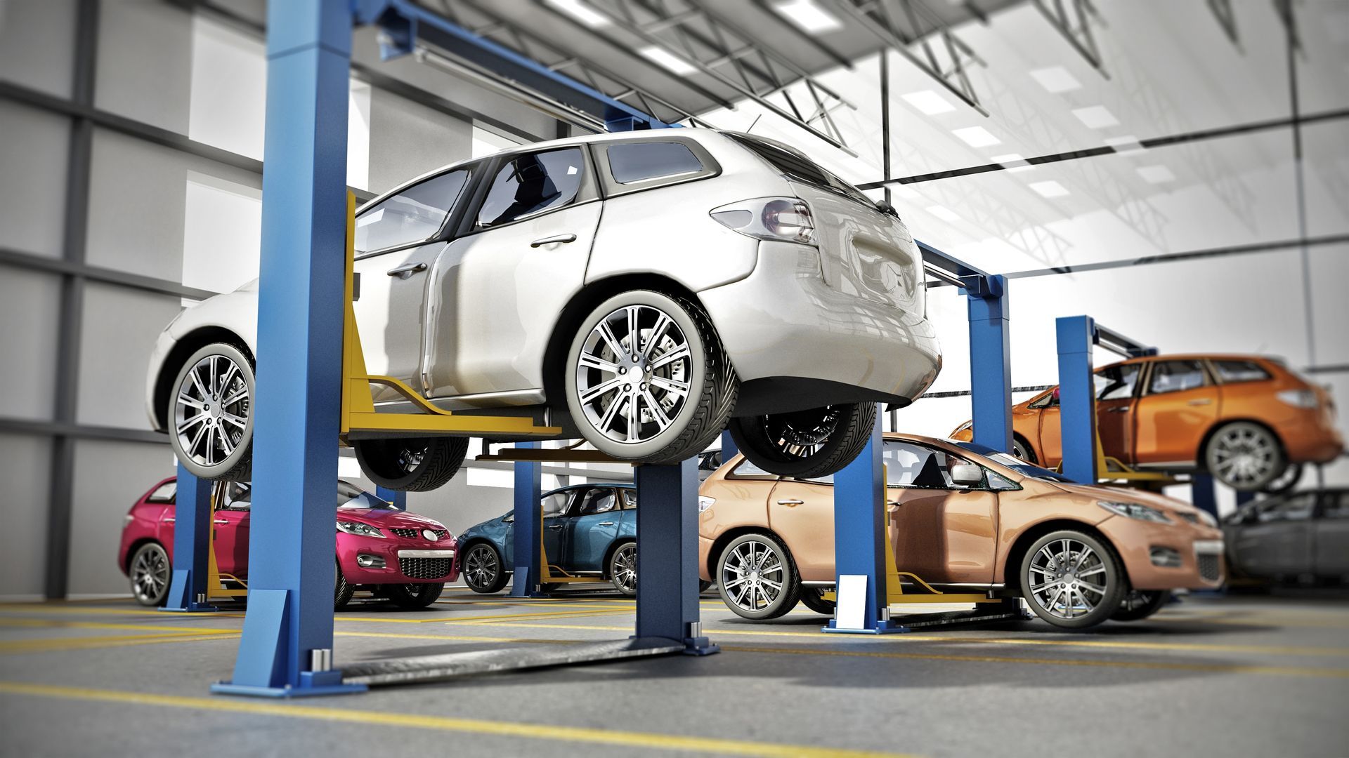 Multiple cars, including white, red, and orange models, are undergoing service on lifts inside a bright auto repair shop.
