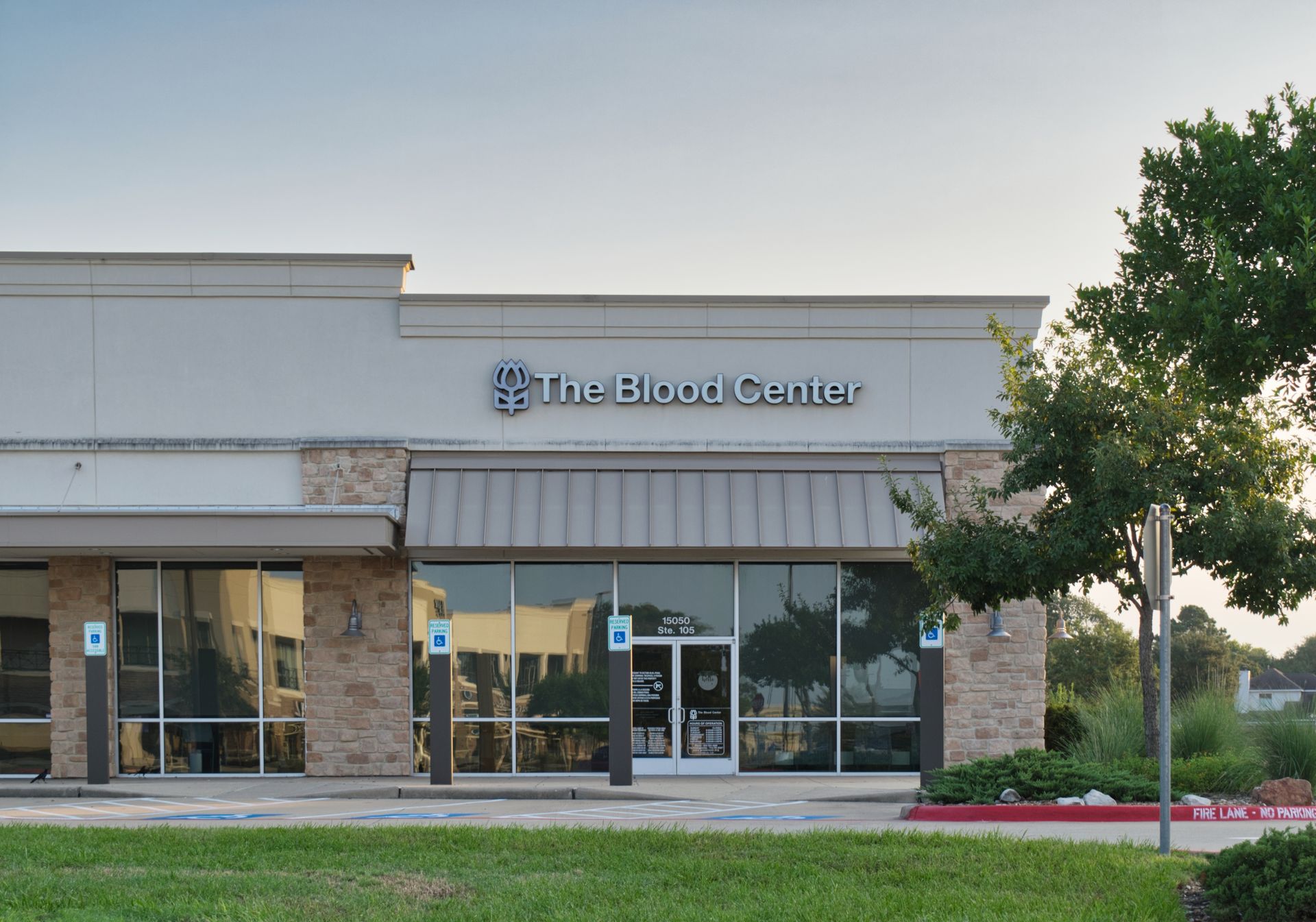 An exterior view of a beige commercial building with a sign that reads