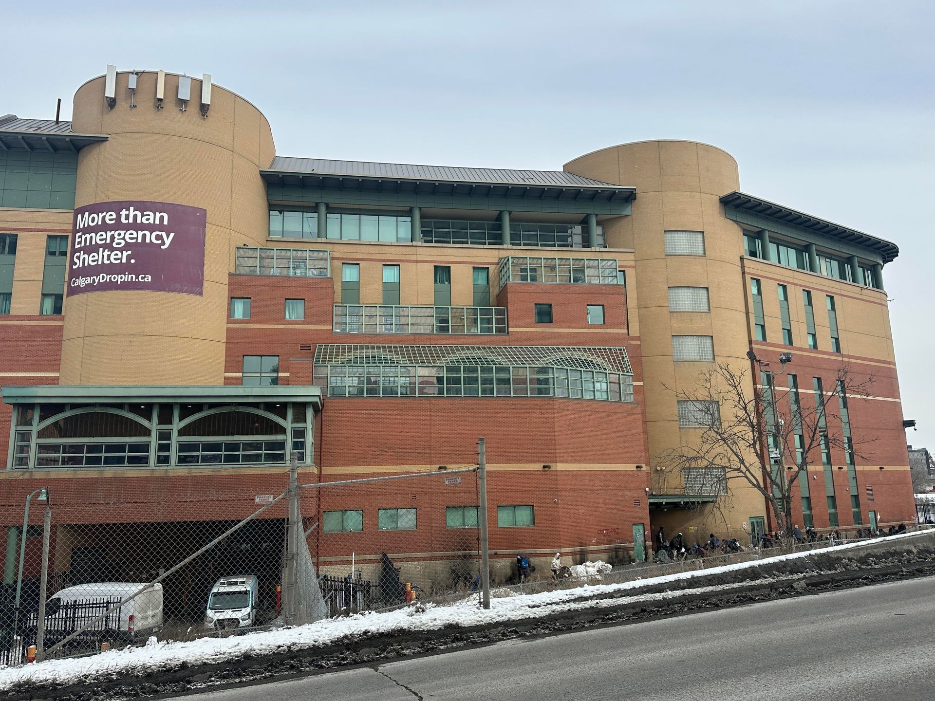 A large, multi-story brick building with rounded towers, featuring a sign reading