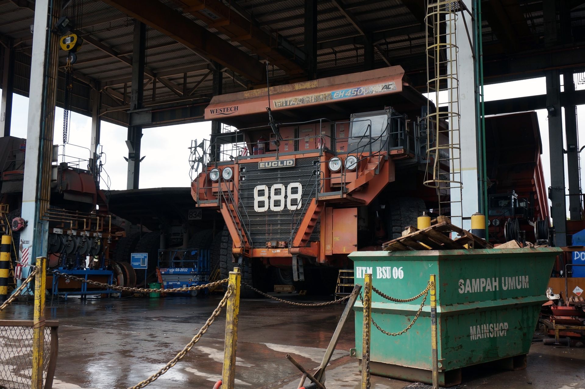 A massive orange mining dump truck labeled 