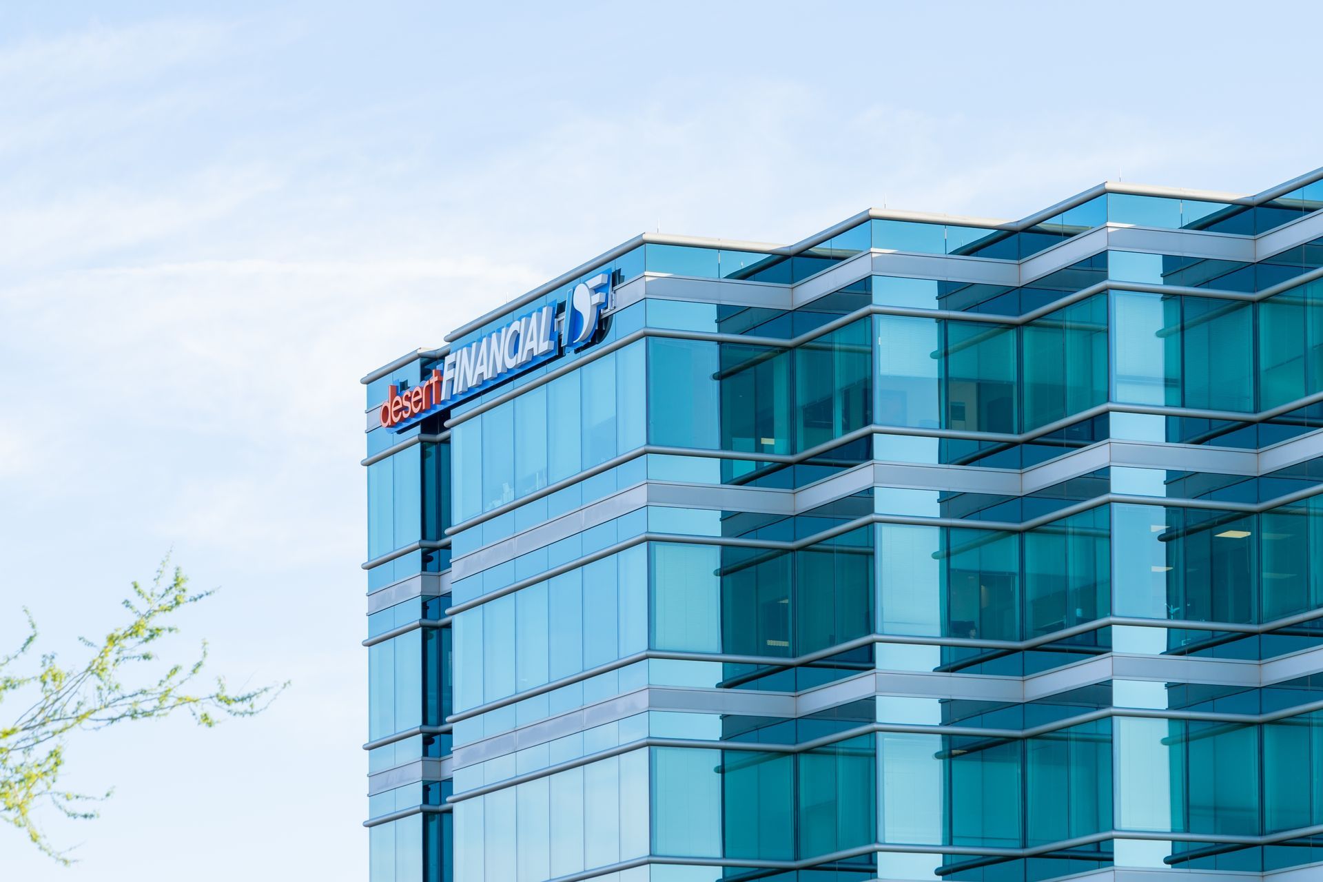 The exterior of a modern office building with blue-tinted glass windows and a prominent 