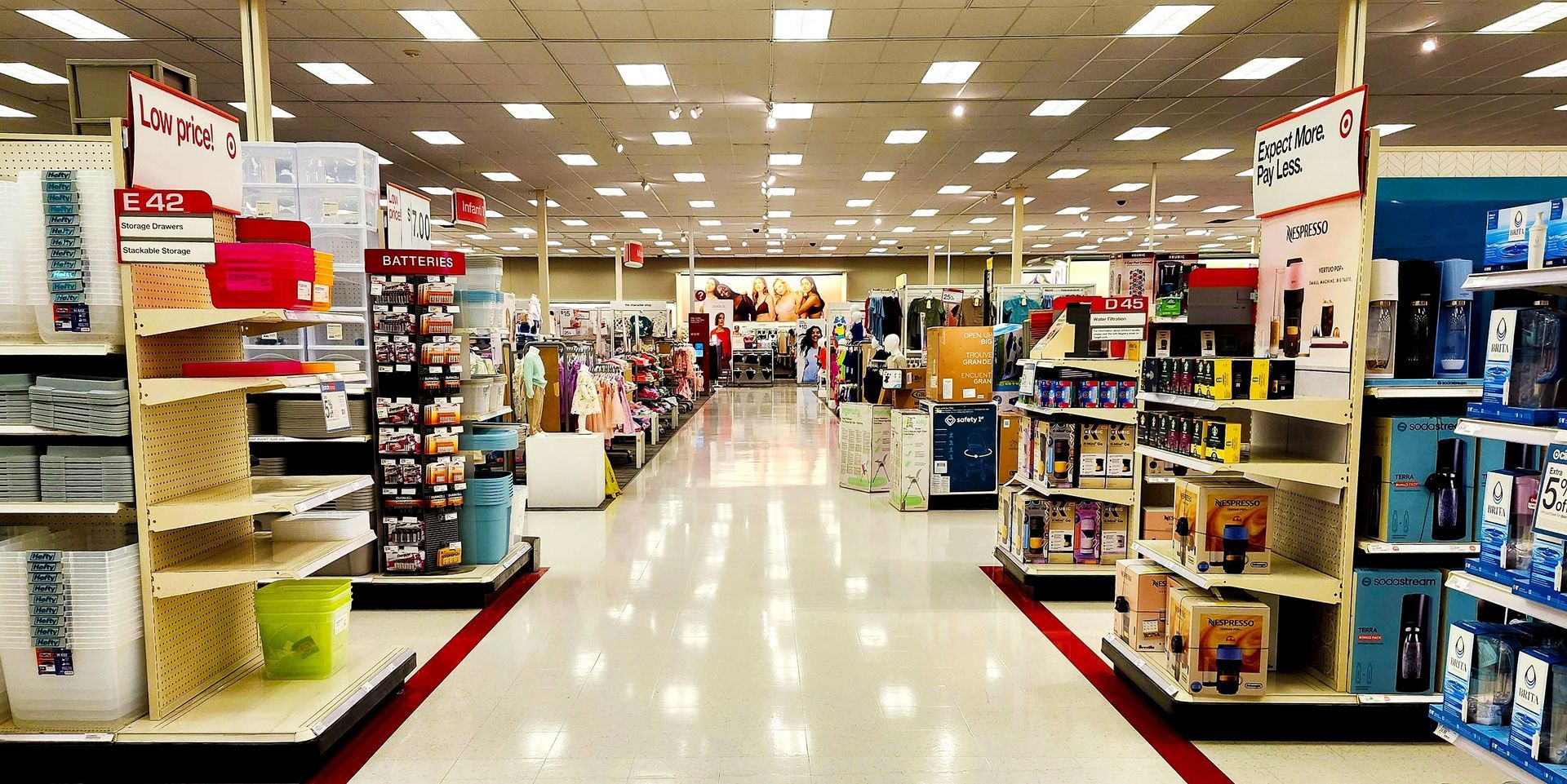 A wide, centered view of an aisle in a Target store with shelves stocked with various retail products.