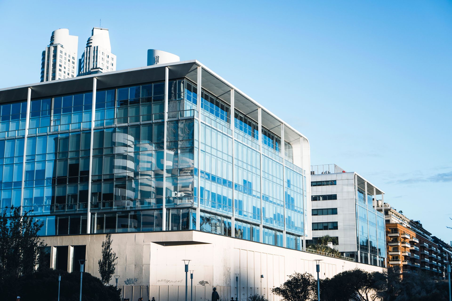Modern glass office building with blue windows and a city street view