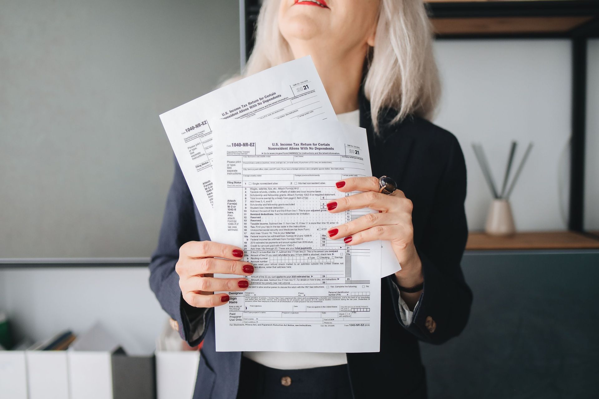 Person holding two forms in an office setting