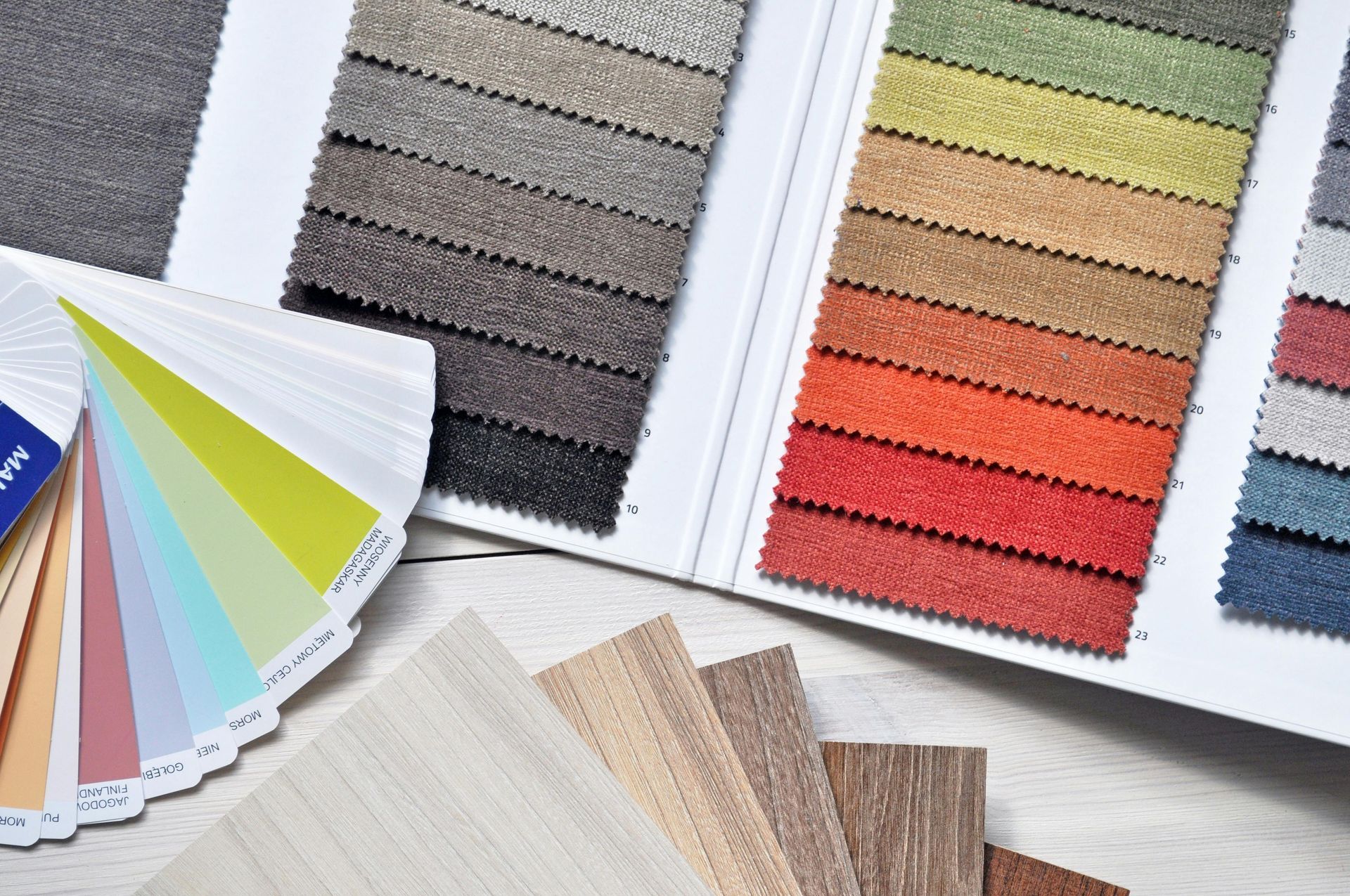 Fabric and color swatches on display, featuring textiles and a paint color fan.