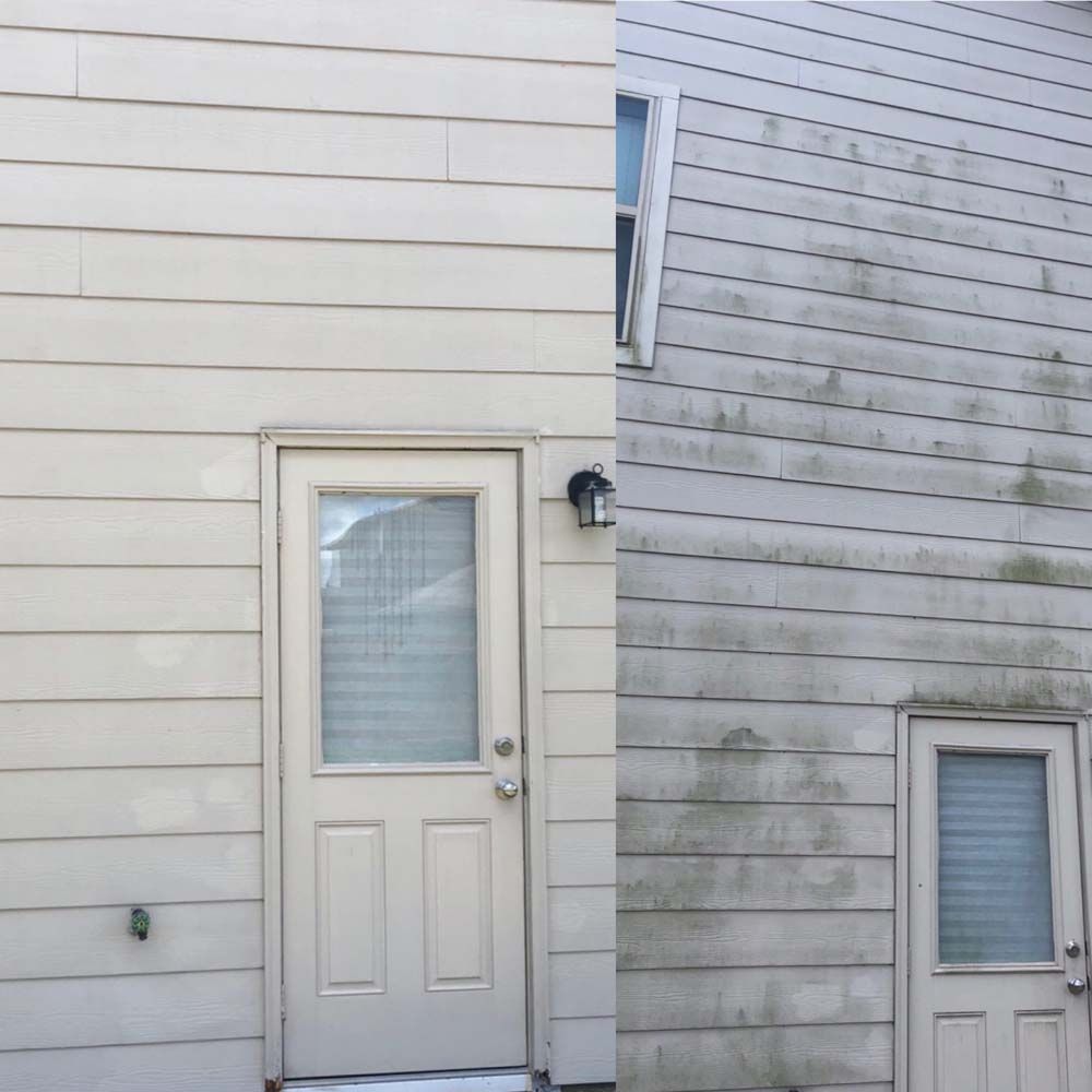 Side of a house with two white doors and weathered siding