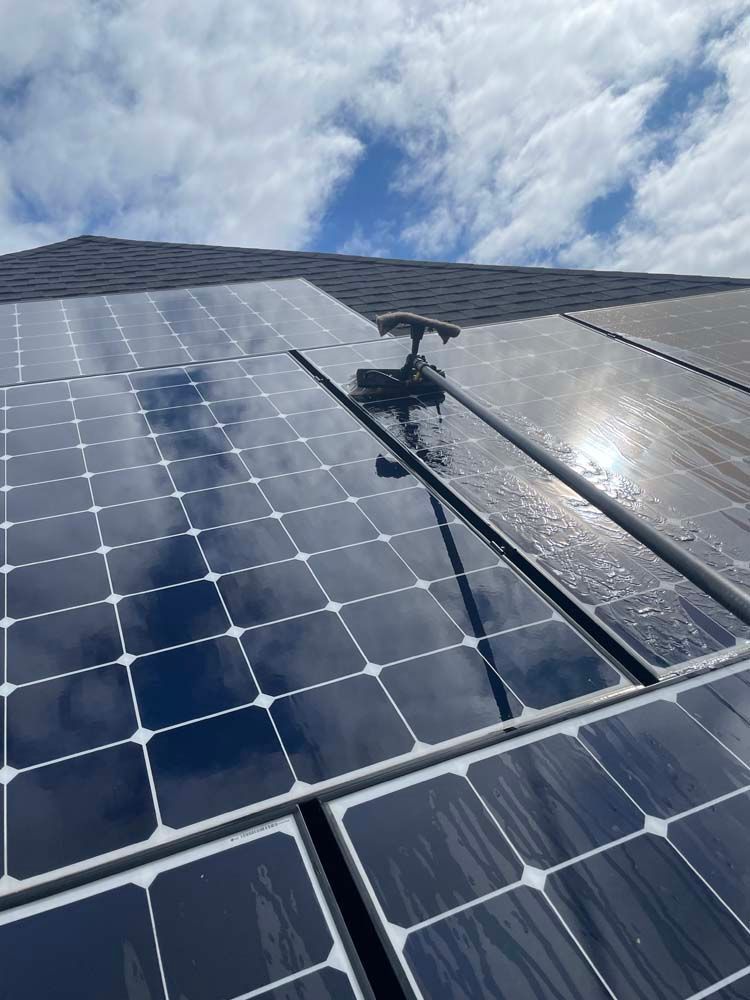 Solar panels with a cleaning robot on a rooftop under a cloudy sky