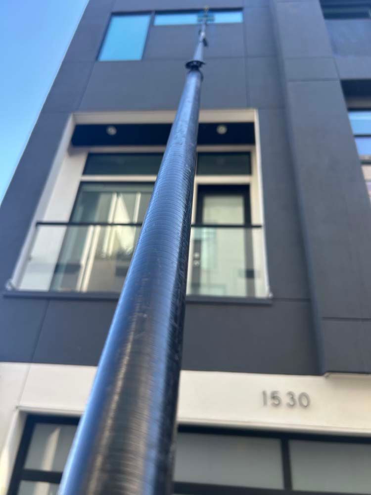Long pole reaching up to a modern building facade with the number 1530 visible above the entrance