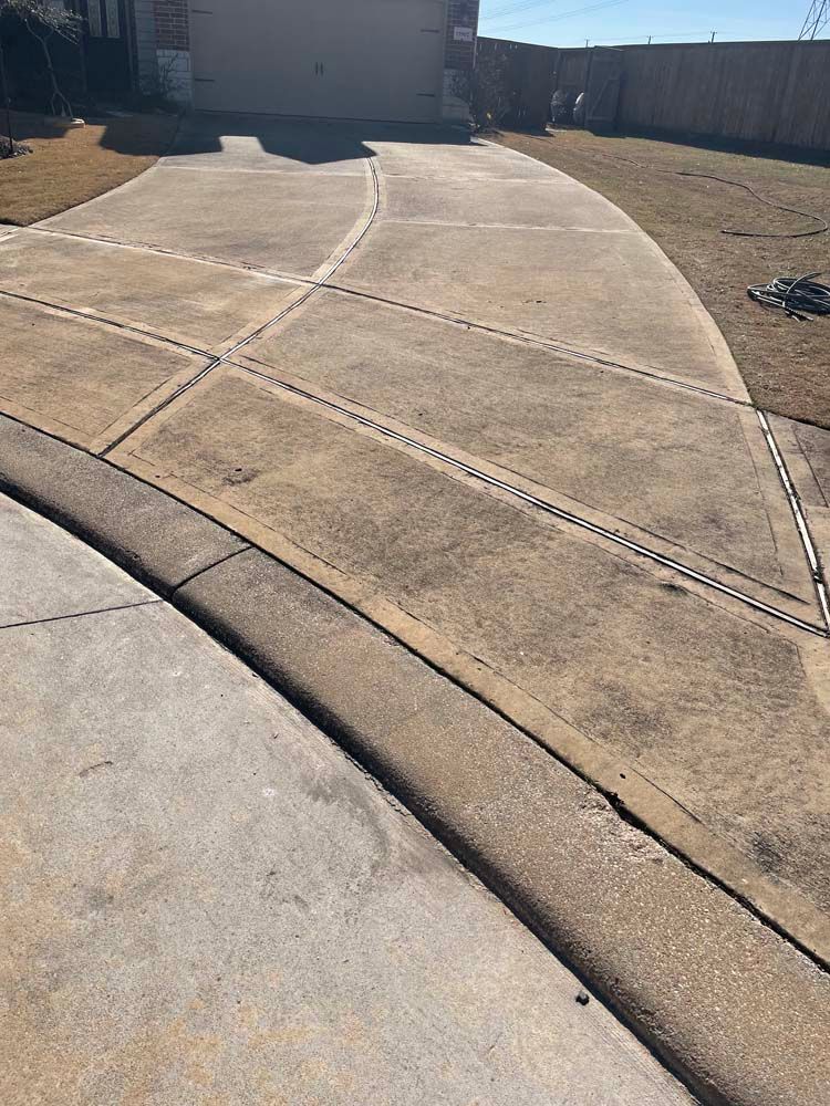 Concrete driveway with decorative seams leading to a garage in a residential yard