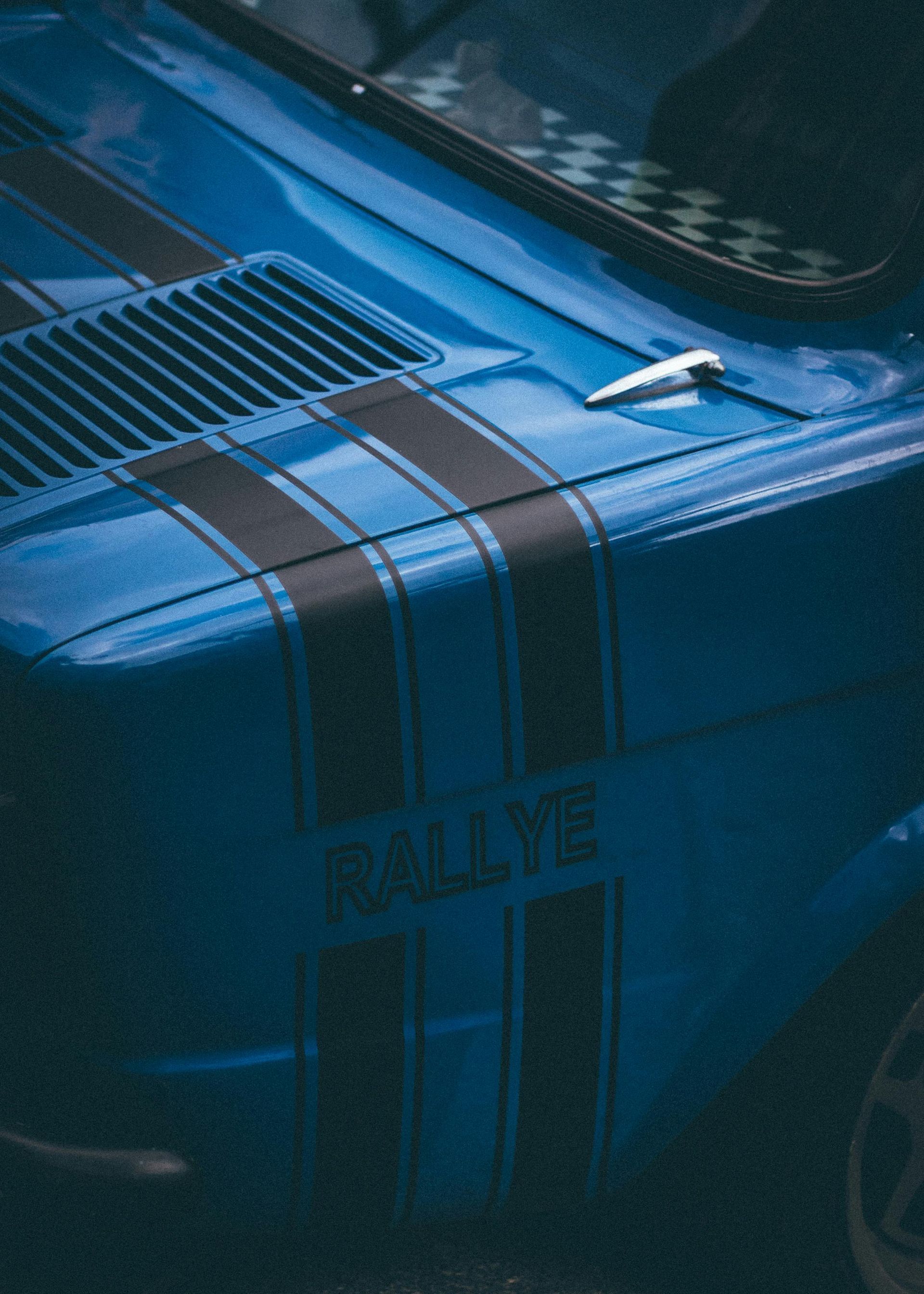 Green, black, and gray Lamborghini race car in a garage with blue honeycomb lights.
