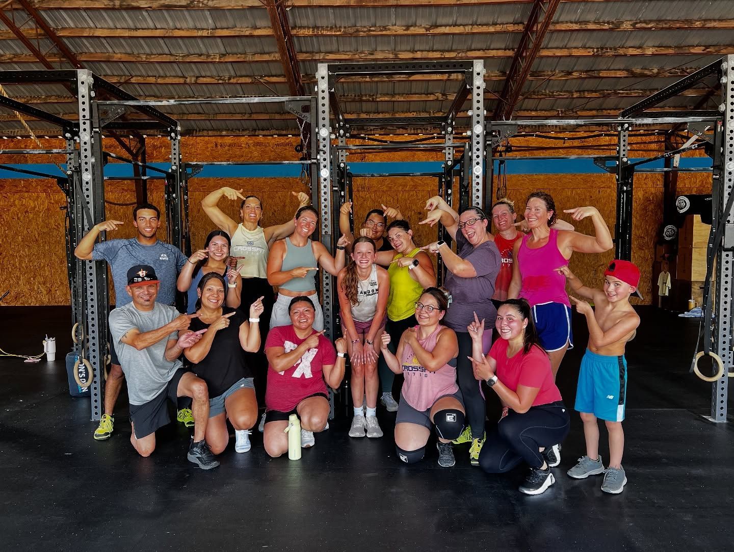 A group of people are posing for a picture in a gym.