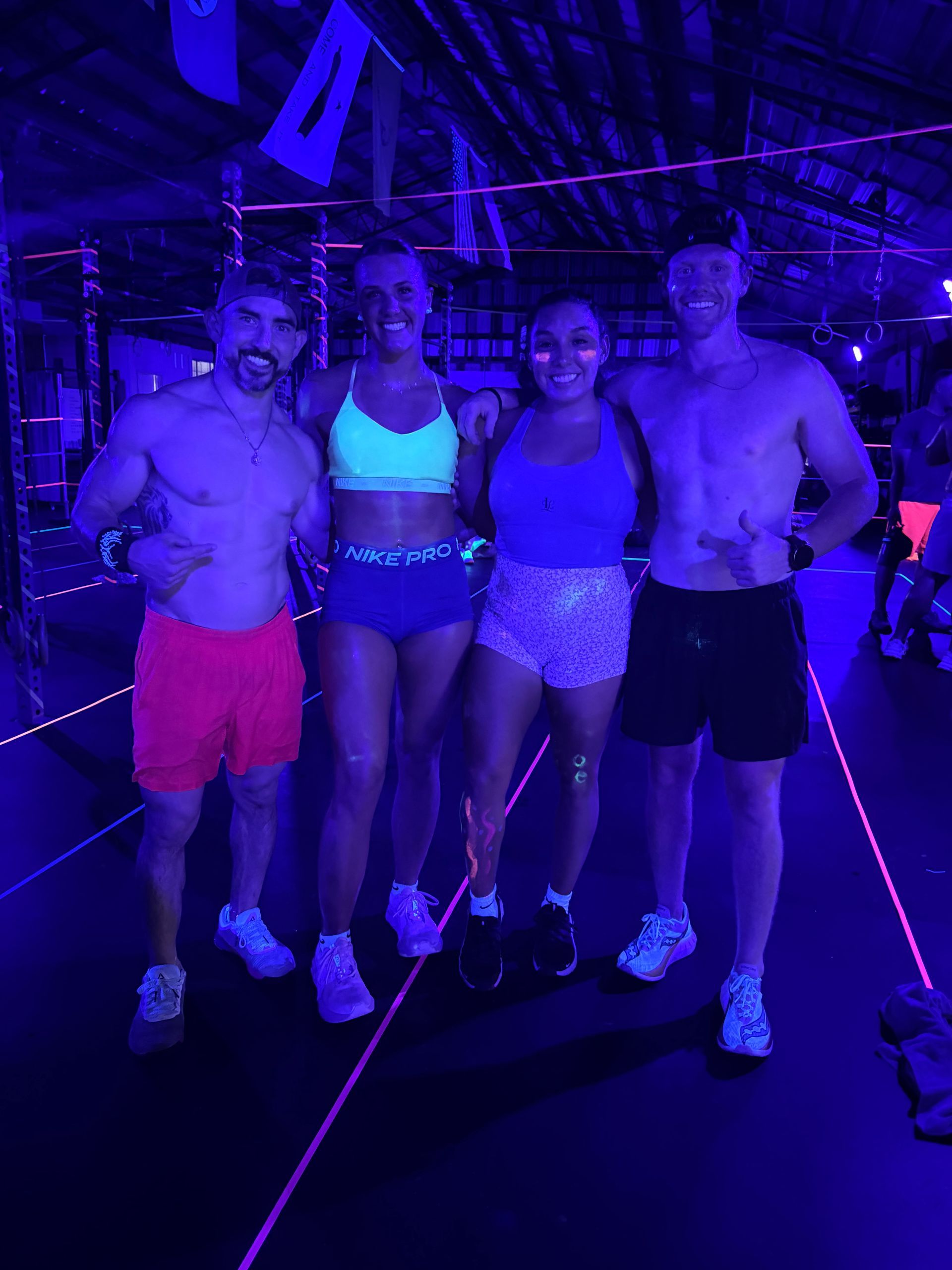 A group of people are standing in a gym.