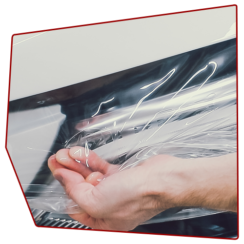 Hand reaching for clear plastic wrap on a machine. Hand reaching for clear plastic wrap on a machine.