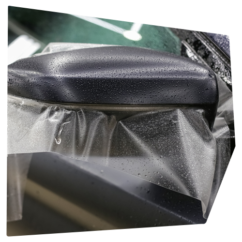 Black object covered in clear plastic with water droplets, angled view. Black object covered in clear plastic with water droplets, angled view.