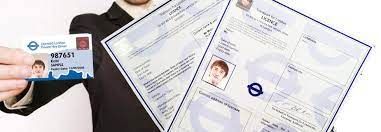 A man in a suit is holding a id card and two papers.
