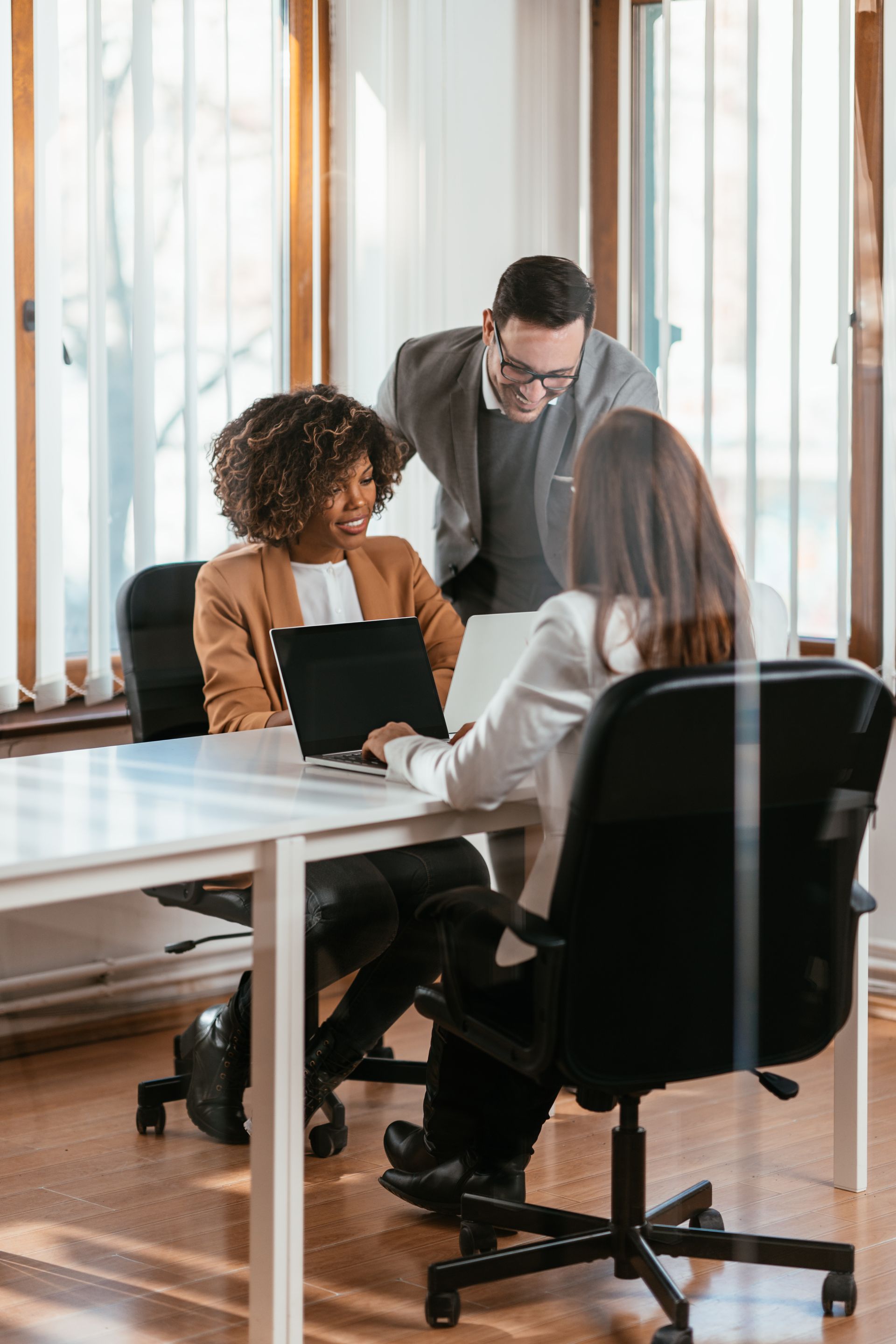 A group of business people are looking at a laptop computer.