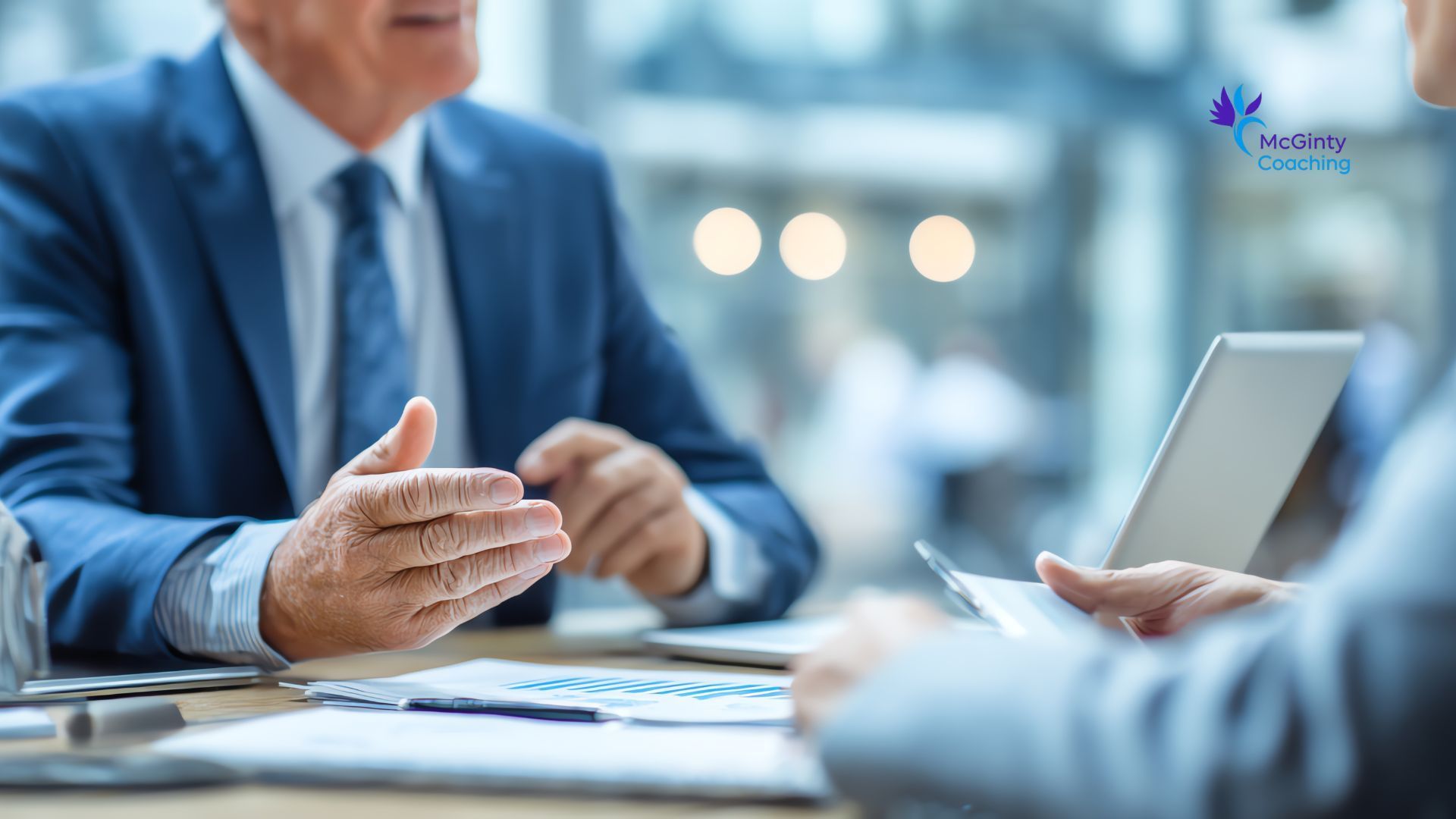 Business meeting with two people discussing documents across a table in a bright office