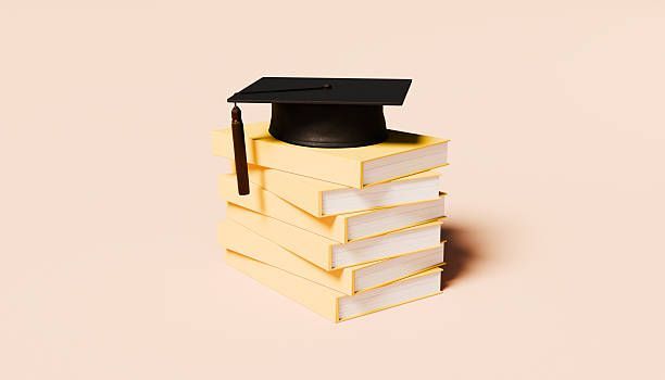 Stack of books with a graduation cap on top against a light background