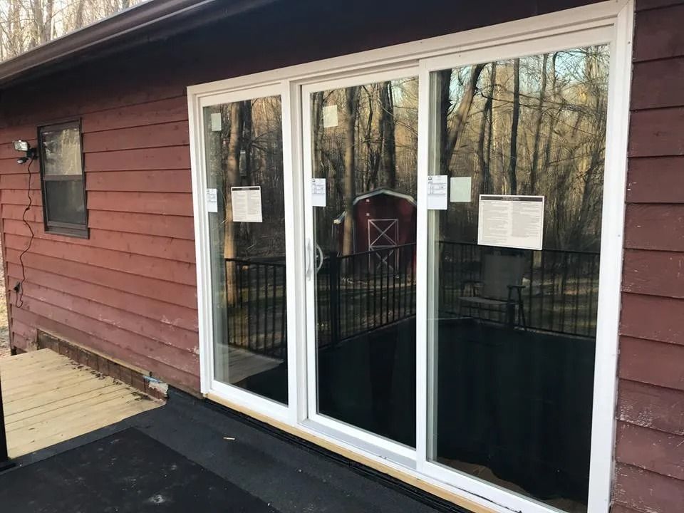 Sliding glass patio door on a red house with notices taped to the panes