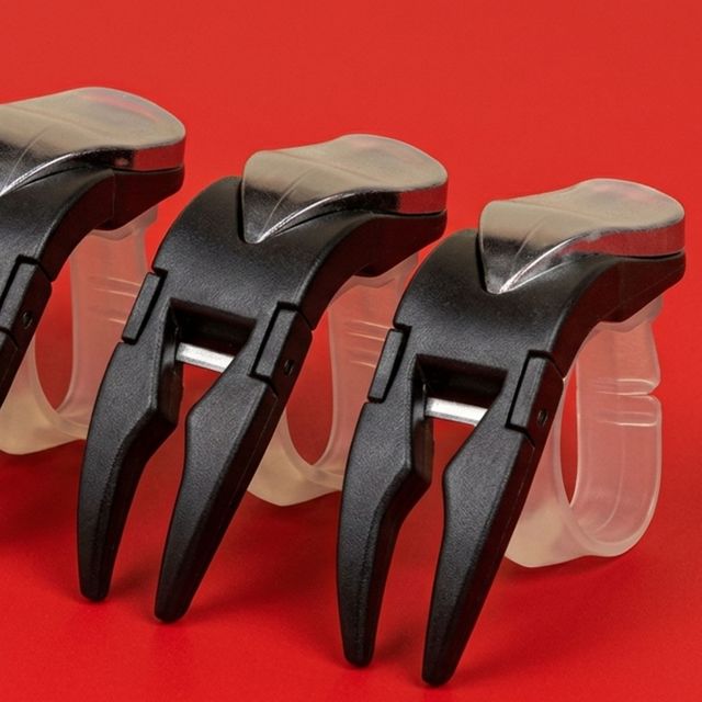 Three black and silver lever handles on clear plastic mounting blocks against a red background
