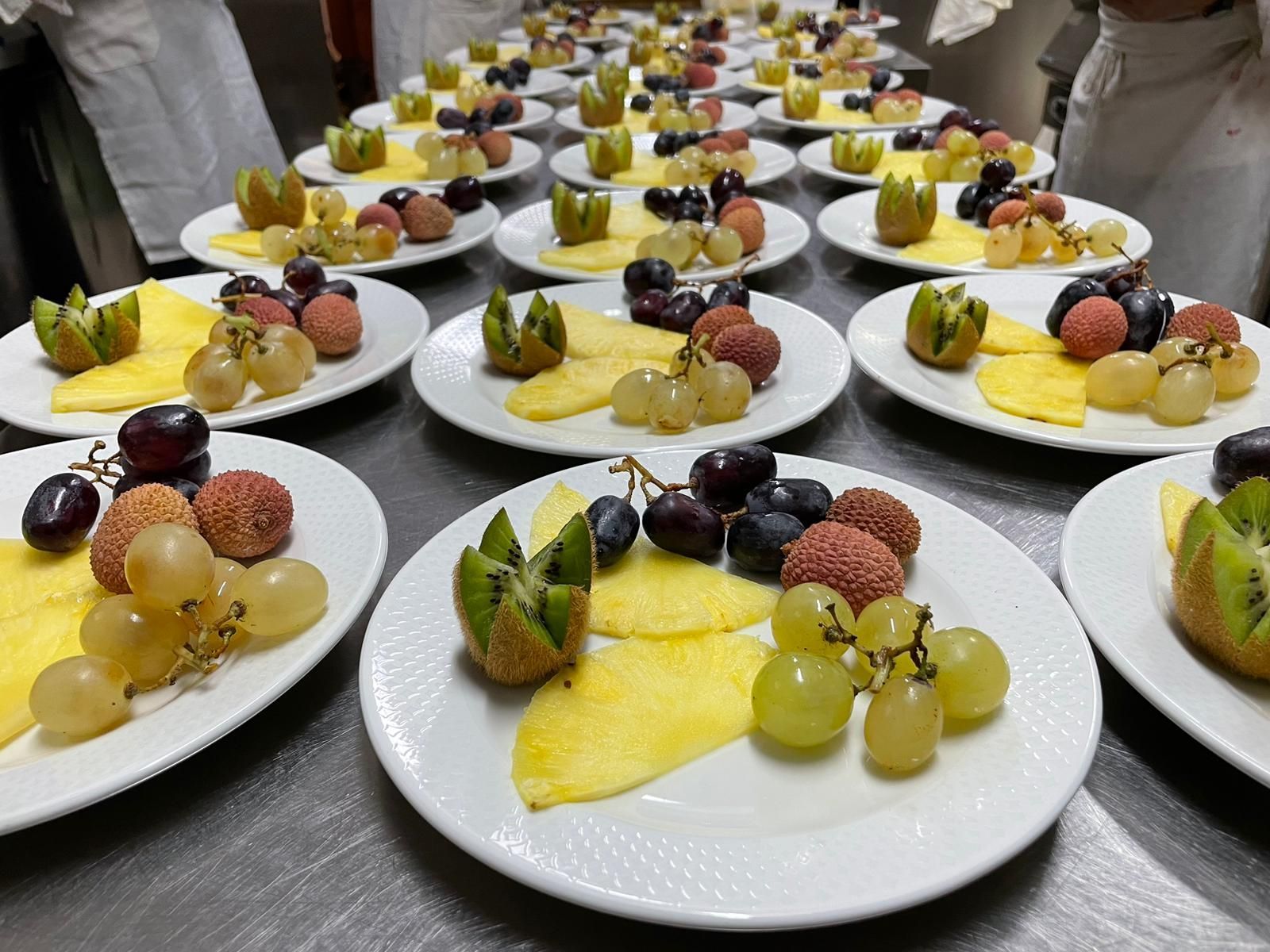 Assortimento di dessert alla frutta serviti su piatti bianchi su un tavolo da banchetto.