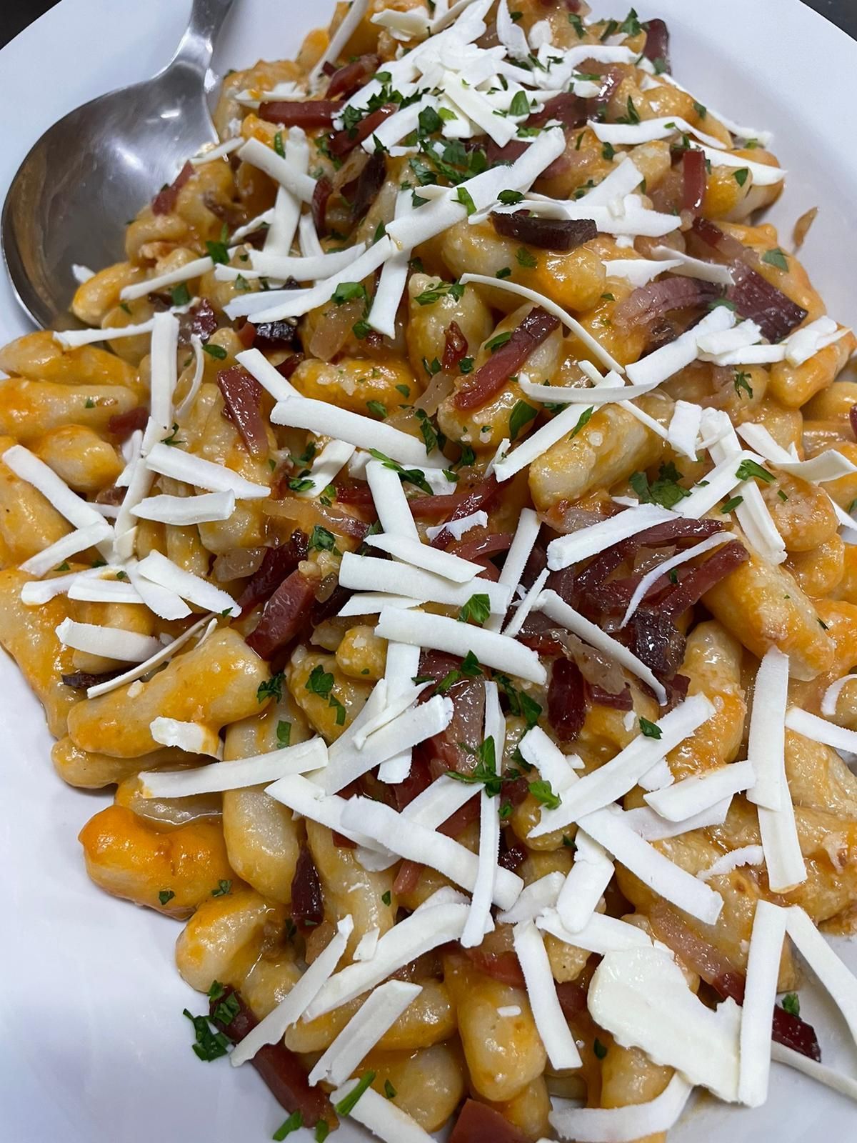 Ciotola di insalata di mais condita con formaggio grattugiato, erbe aromatiche e salsa.