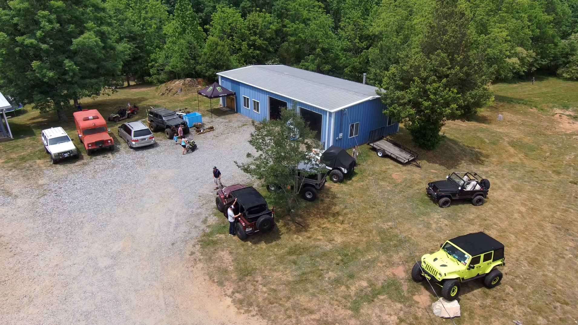 An aerial view of a garage with a bunch of jeep 's parked in front of it.