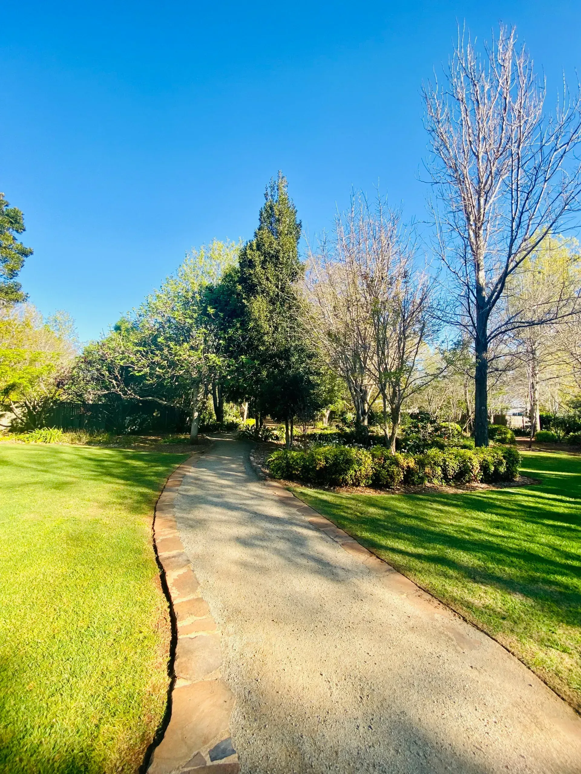 A Gravel Path Winds Through a Sunny Park — Garden City Slashing in Highfields, QLD