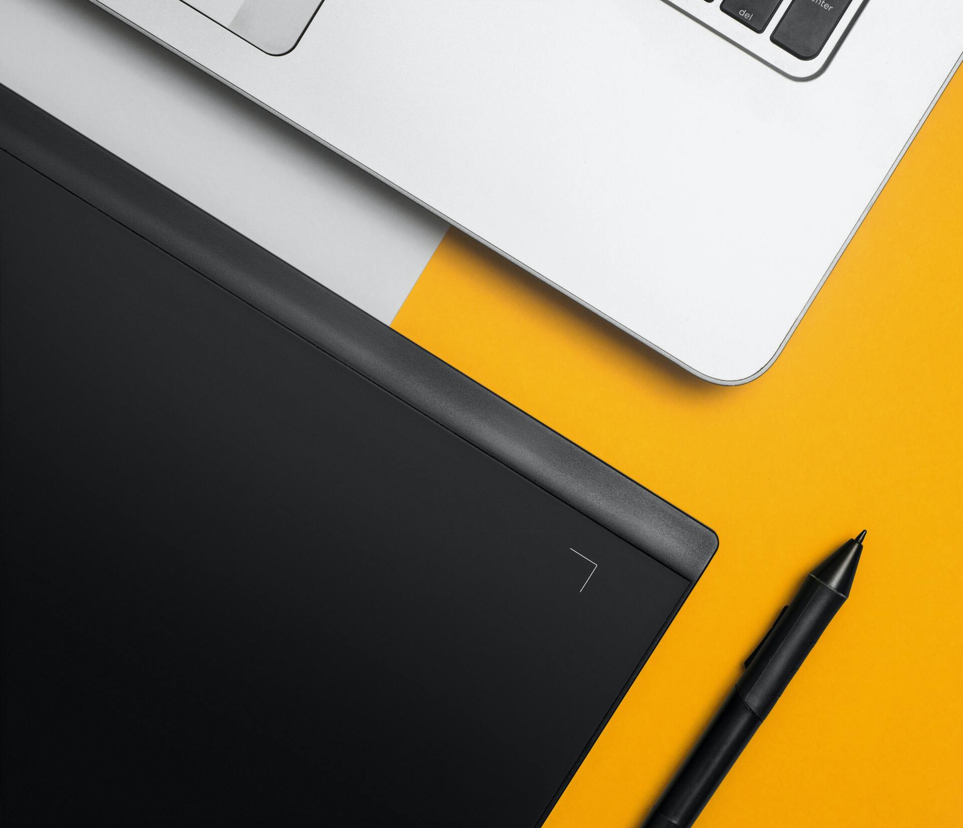 a notebook, a pen and a laptop sitting neatly on a table