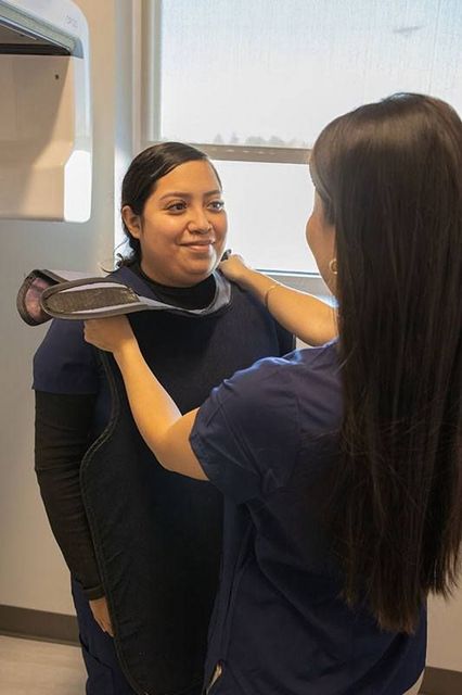 Person fitting a neck brace on another person in a clinic room