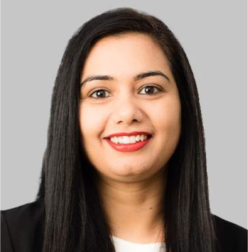 Smiling woman with straight dark hair in a black blazer against a light gray background