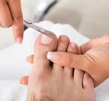 Foot being trimmed with nail clippers during a pedicure