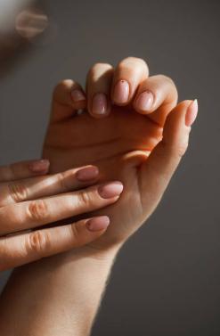 Hands gently touching each other against a neutral brown background