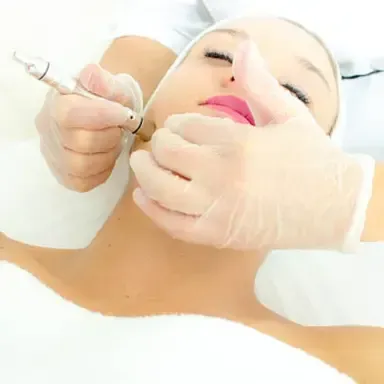 Cosmetic injection being administered to a reclining woman's face by gloved hands