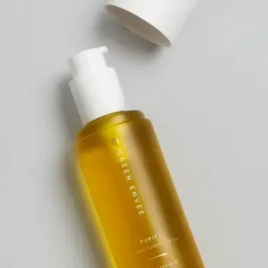 Gold skincare bottle with white pump and cap on a light background