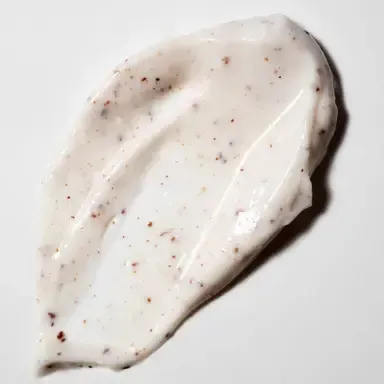White creamy sauce with brown specks spread in a dollop on a white background