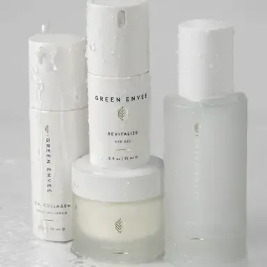 White Green Envee skincare bottles and jars arranged on a light background.