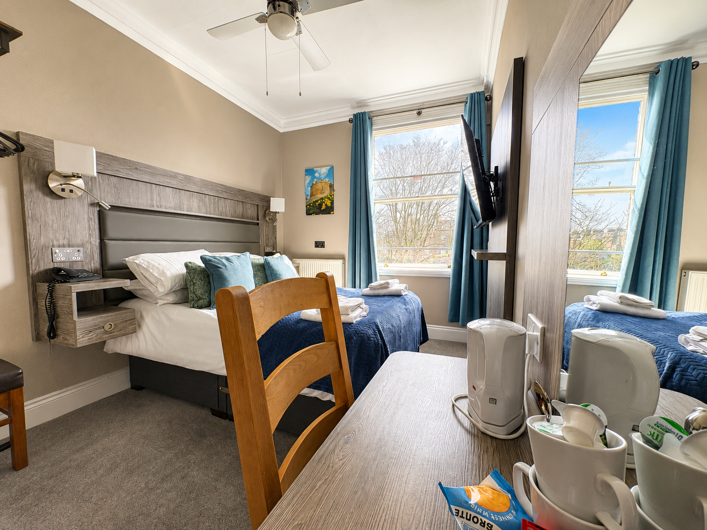 Hotel bedroom with a double bed, bathroom visible through the doorway, neutral colors.